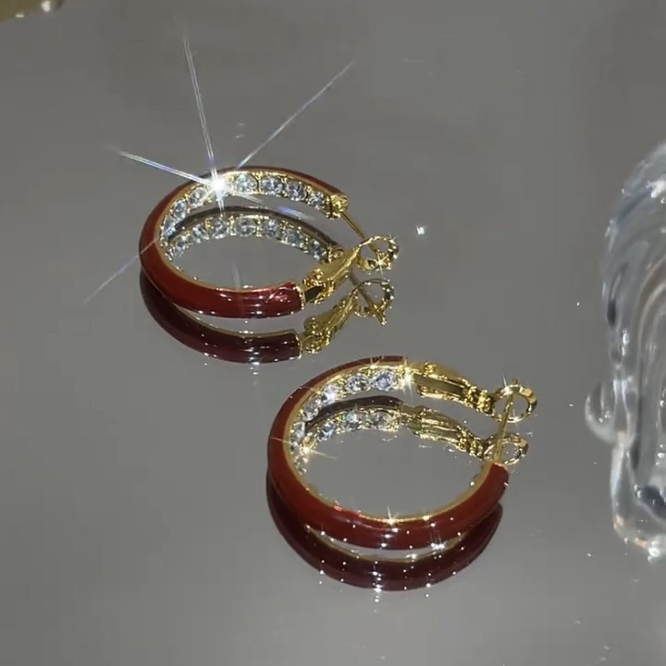 Boucles d’oreilles créoles dorées avec détails émaillés et strass